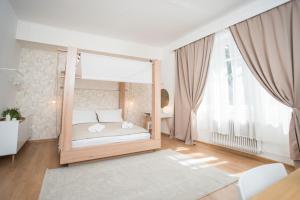 a bedroom with a canopy bed and a large window at Penzión Branecky in Trenčín
