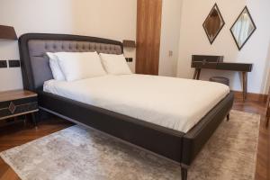 a bedroom with a large bed with a black frame at Porto Montenegro Luxury 1 Bedroom Apartment in Tivat +26 photos