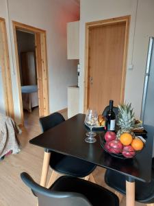 a black table with a bowl of fruit and wine glasses at Kima House in Kalamaki