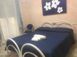 a bedroom with a blue bed with towels on it at A Casa di Nunzi in Tropea