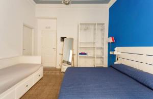 - une chambre avec un lit et un mur bleu dans l'établissement Charmie flat, à Palerme