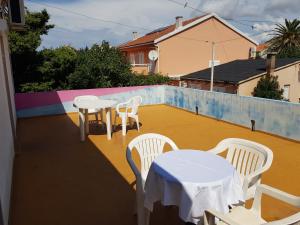 a patio with tables and chairs on a roof at PORTA NOVALIS Rooms in Novalja