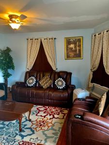 a living room with a leather couch and a table at The dream stylish apartment near Providence in Pawtucket