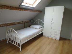 a bedroom with a white bed and a cabinet at Kustverhuur, Breskens, 't Zandertje in Breskens