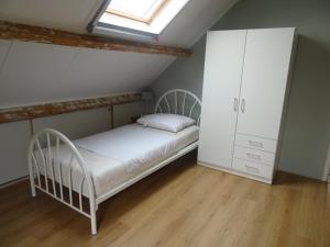 1 dormitorio con 1 cama blanca y armario en Kustverhuur, Breskens, 't Zandertje, en Breskens