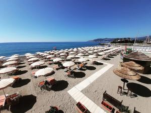 a bunch of umbrellas and chairs on a beach at Don Pedro Beach House in Savona