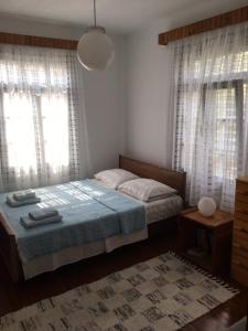 a bedroom with a bed and two windows and a rug at Summer Den Plus in Ierissos