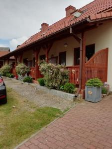 una casa con tetto rosso e vialetto di mattoni di Apartamenty Kołczewo a Kołczewo