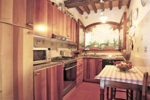 - une cuisine avec des placards en bois et une table avec un bol de fruits dans l'établissement Apartment in B&B Del Giglio, à San Donato in Poggio