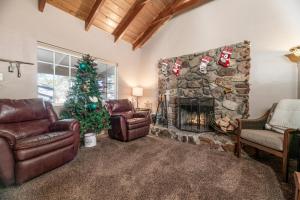 a living room with a fireplace and a christmas tree at 060 - The Angeles Chalet in Big Bear City