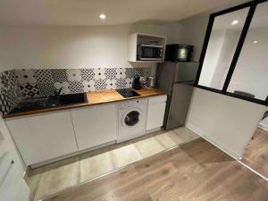 a kitchen with a sink and a washing machine at Le Black & White, hyper centre - paisible- wifi HD- NETFLIX- proche gare -Ideal couple et business in Niort