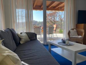 - un salon avec un canapé bleu et une table dans l'établissement Ferienwohnung im Vorbachtal, à Niederstetten