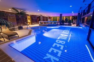 a large swimming pool with people in the water at Hotel Thermen Dilbeek in Dilbeek