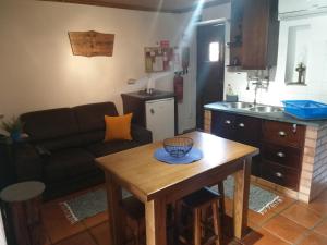 a living room with a table and a kitchen at Casa do Alto in Penacova