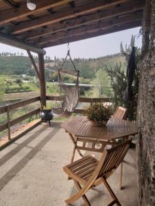 a patio with a hammock and a table and chairs at Casa do Alto in Penacova