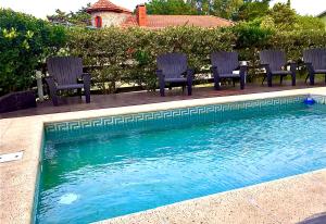 a group of chairs sitting next to a swimming pool at Departamentos NIZA 313 in Ostende