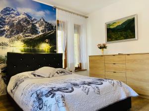 een slaapkamer met een bed en een foto van de bergen bij Apartament Rodzinny Gubałówka in Zakopane