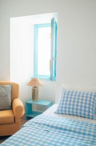 a bedroom with a bed and a chair and a window at Xicotina in Moledo