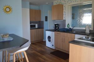 a kitchen with a sink and a washing machine at Bachylis Self Catering in Kirkwall