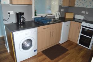 a kitchen with a washing machine and a sink at Bachylis Self Catering in Kirkwall