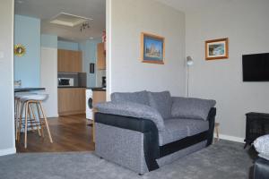 a living room with a couch and a kitchen at Bachylis Self Catering in Kirkwall