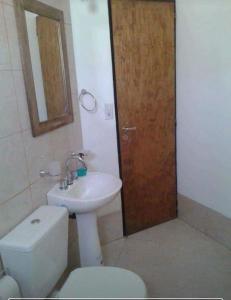 une salle de bain avec toilettes, lavabo et miroir dans l'établissement Patagonia Beach Las Grutas!, à Las Grutas 5 autres photos