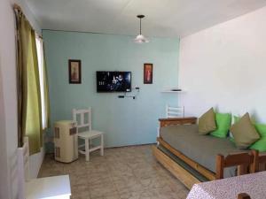 un salon avec un lit et une télévision à écran plat dans l'établissement Patagonia Beach Las Grutas!, à Las Grutas