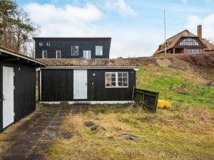 a black and white house on top of a hill at Holiday home Allingåbro XXIII in Allingåbro