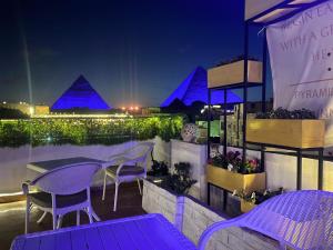 a patio with purple tables and chairs at night at Pyramids Top Inn in Cairo