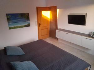 a bedroom with a bed and a flat screen tv at Weite Blicke in Horn in Horn-Bad Meinberg