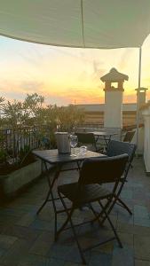 a table and chairs on a patio with the sunset at Casa Cavour in Garda