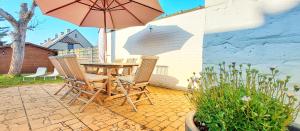 a patio with a table and chairs and an umbrella at Huize Andries in Bruges