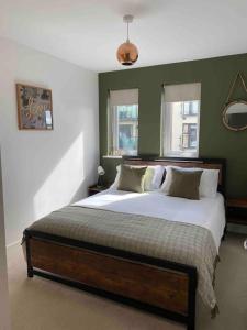 1 dormitorio con 1 cama grande y paredes verdes en Luxury 2 Bedroom waterfront apartment with balcony, en Newport