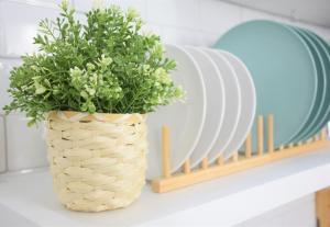 a plant in a basket on a shelf next to plates at Casinha da Esquina - Refúgio Alentejano a 700m da Praia in Amieira +25 photos