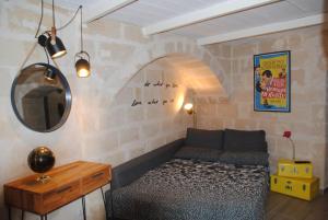 a living room with a bed and a mirror at La Perla dei Sassi in Matera