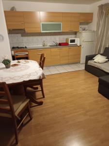 Apartman Skradin في سكرادين: غرفة معيشة مع طاولة ومطبخ