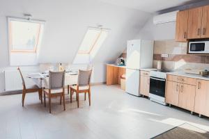 a kitchen with a table and chairs and a refrigerator at Bor, Villa, Sóstó in Nyíregyháza