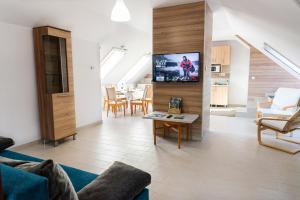 a living room with a couch and a tv on a wall at Bor, Villa, Sóstó in Nyíregyháza