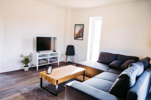 ein Wohnzimmer mit einem Sofa und einem Couchtisch in der Unterkunft Ferienhaus am Diemelsee - WLAN / Sauna / Strand - Sport & Erholung in Heringhausen