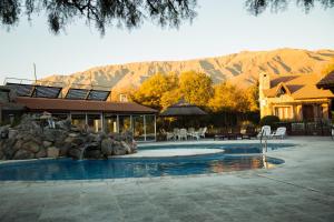 a swimming pool in front of a house with mountains at La Quinta Resort in Merlo