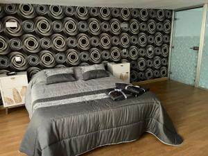 a bedroom with a large bed with a black wall at TEMPLE LOFT in Talavera de la Reina
