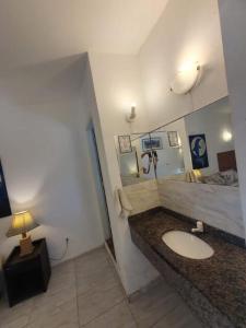 a bathroom with a sink and a mirror at Suites Geriba in Búzios