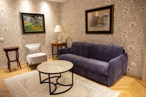 uma sala de estar com um sofá azul e uma mesa em Seven Luxury Suites em Tirana
