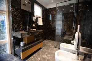 a bathroom with a sink and a shower and a toilet at Seven Luxury Suites in Tirana