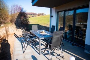 a wooden table and chairs on a patio at Haus am Diemelufer - Natur pur, private Sauna - der Luxus der Stille in Heringhausen