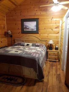 a bedroom with a bed in a wooden cabin at Beary Cuddly Hottub 10 Mins Downtown Gatlinburg National Park in Gatlinburg