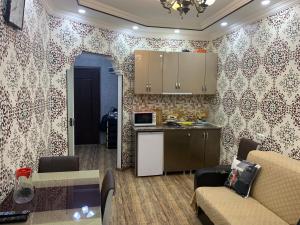 a kitchen and a living room with a couch and a table at Gorgasali street Apartment in Batumi