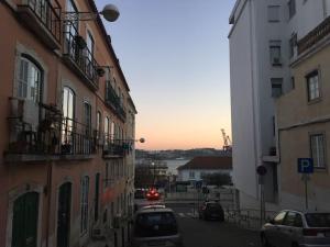a city street with buildings and cars parked on the street at Cozy Estrela Apartment in Lisbon
