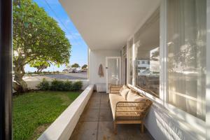 a porch with a couch and chairs on a house at Houston Beachfront Apartments in Gold Coast