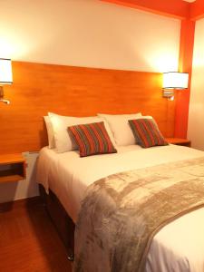 um quarto de hotel com uma cama grande com duas almofadas em Amakonkay Machupicchu em Machu Picchu